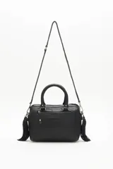 Cartera negra de cuero vacuno con correa desmontable, doble asa corta y cierre superior. Diseño matelassé con tachas metálicas plateadas y doradas en el frente y laterales con cierre.
