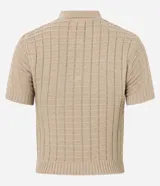 Blusa color beige de tejido de punto con textura cuadriculada, corte crop, cuello polo con cierre de botones y mangas cortas ajustadas.