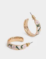 Aros tipo argolla dorados con flores esmaltadas en tonos rosa y verde.