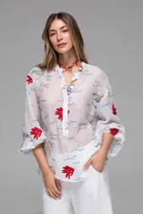 Camisa blanca de gasa transparente con bordados de corales y estrellas de mar. Tiene mangas largas con elástico y corte cómodo.