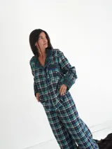 Conjunto de pijama a cuadros con ribetes en color lila, compuesto por camisa de manga larga con botones y pantalón largo.