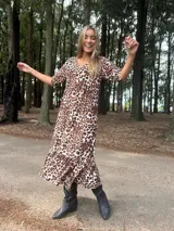 Vestido largo de fibrana y viscosa con estampado animal print, corte holgado, mangas cortas y ruedo con volantes.