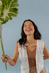 Chaleco blanco de encaje con diseño floral, corte sastrero y sin mangas.