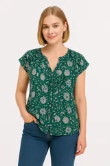 Blusa verde con estampado floral en blanco, con escote en V y mangas cortas.