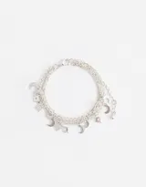 Pulsera plateada multicadena con dijes de lunas y estrellas.