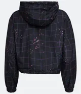 Campera cropped con capucha, de poliéster color negro con estampado de cuadros y salpicaduras de colores. Tiene cordón de ajuste en la capucha, elástico en puños y ruedo, bolsillos con cremallera y cierre frontal con cremallera.
