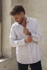 Camisa blanca de corte slim fit, manga larga y cuello clásico. Cierre frontal con botones.