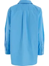 Camisa celeste de popelín de algodón orgánico, corte oversize con hombros caídos, cuello inglés, bolsillo de parche en el pecho y logo bordado en la manga.