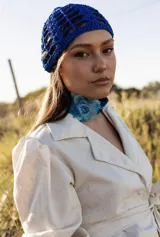 Casquete azul tejido en hilo de seda viscosa, con diseño calado.