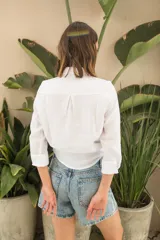 Camisa blanca de lino, de corte clásico, con cuello camisero, manga larga y bolsillo en el pecho.