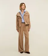 Pantalón recto de cintura alta, confeccionado en terciopelo cotelé color beige, con trabillas en la cintura, cierre tradicional y bolsillos delanteros.