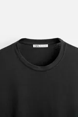 Camiseta negra de manga larga y cuello redondo, corte slim fit.