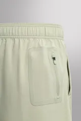 Shorts de entrenamiento color verde claro, confeccionados en tejido técnico ligero y elástico. Sin forro interior, con cintura elástica ajustable con cordón interior, bolsillos frontales y bolsillo trasero de seguridad con cierre de cremallera. Bajo con acabado termofijado y aberturas laterales.