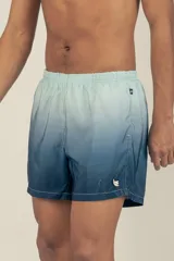 Short de baño con degradé de celeste a azul marino, con cintura elástica ajustable, dos bolsillos laterales y uno trasero con cierre. Cuenta con suspensor de malla fina hipoalergénico y protección UV 50.