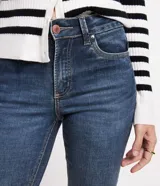 Pantalón de jean azul oscuro, modelo cropped recto, con cintura fija con trabillas, bolsillos y cierre delantero con botón y cremallera.