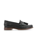 Mocasín de cuero negro con borlas decorativas y suela marrón.