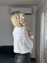 Blusa negra con estampado de lunares blancos, escote en V cruzado, mangas 3/4 abullonadas y hombreras. Talle único abarca hasta L.