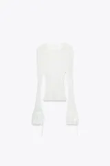 Top semitransparente de encaje blanco, con cuello redondo y mangas largas acampanadas con volantes ajustables con lazada.