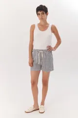 Short de tela color blanco con rayas verticales negras, cintura elastizada con cordón ajustable.