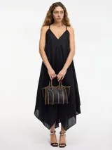 Vestido negro con escote en V y breteles finos. Corte evasé amplio con caída en picos.