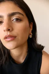 Aros de acero quirúrgico hipoalergénico con piedras naturales azules. Diseño de aro con dije circular colgante.