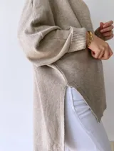 Sweater beige de tejido de punto con cuello redondo y mangas largas.