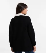 Cardigan alargado color blanco, con cuello virada, forro de pelos y confeccionado en punto pesado. No tiene cierre.