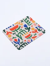 Mousepad rectangular con base de goma negra y superficie de tela estampada con diseño floral abstracto multicolor.