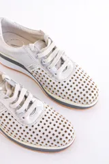 Zapatillas de cuero color dorado con diseño perforado, cordones blancos y suela de goma.