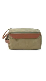 Neceser verde de tela canvas con detalles en cuero marrón. Tiene doble cierre superior, bolsillos internos con cierre y abiertos, bolsillo frontal con solapa y asa lateral.