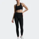 Calza de compresión larga, color negro, de tiro alto y tejido suave. Presenta costuras planas y detalles de logotipo tonales mínimos.