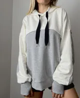 Canguro gris con capucha y tajo en las mangas, fabricado en algodón y diseño cómodo.