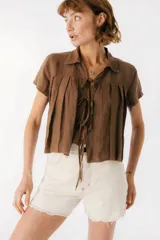 Camisa celeste de lino con cuello clásico, mangas cortas, corte crop y lazos en el frente.