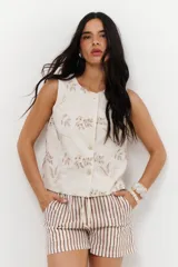 Musculosa color crema con bordado de hojas y flores en color beige, con botones frontales.