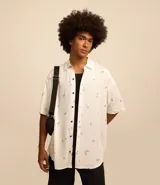 Camisa blanca de viscosa con estampado de cocoteros, corte relaxed, cuello inglés, manga corta y cierre abotonado.