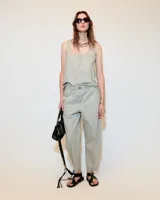 Top sin mangas color verde claro, confeccionado en poplin paper gastado 100% algodón con efecto vintage. De fit relajado, tiene escote redondo bajo, cartera oculta y pequeños recortes a los costados en el ruedo lateral.