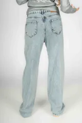 Pantalón de jean celeste de corte wide leg con roturas en las rodillas y apliques de strass.