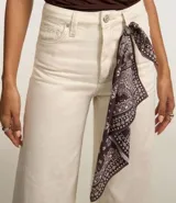 Pantalón wide leg color crudo con estampado paisley y pañuelo estampado en la cintura.