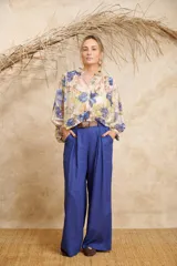Pantalón ancho color beige de lino con cinto y pretina con elástico en la parte de atrás.