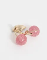 Broche con forma de cerezas rosadas con glitter, hoja verde y detalles dorados.