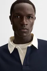 Sudadera tipo polo con cuello clásico, manga larga y diseño a rayas horizontales en color verde oscuro y crudo.