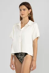 Camisa color crema de lino y tencel, de manga corta, con cuello camisero y cierre abotonado al frente.
