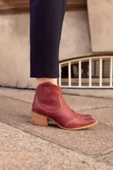 Bota texana de caña baja color marrón con efecto vintage, confeccionada en cuero vacuno y forrada en cuero. Tiene taco de 5cm y cierre lateral.