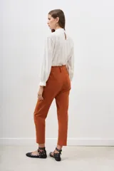 Pantalón de vestir color ladrillo, corte recto, con cintura elastizada y bolsillos laterales.