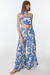 Pantalón palazzo de tiro alto con estampado floral en tonos beige y azul.