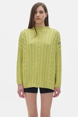 Sweater tejido color verde lima, con cuello alto, mangas largas y diseño oversized.