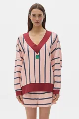 Buzo de algodón lavado a rayas rosas y azul marino, de fit oversized, manga larga y hombros caídos. Cuello en V, terminaciones a contratono y parche en el frente.