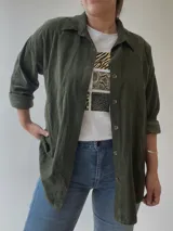 Camisa azul marino de pana fina con botones marrones, corte holgado y mangas largas.