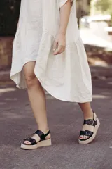 Sandalias negras de cuero con plataforma beige y doble tira con hebilla.