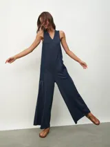 Mono largo color beige, de corte holgado, con cuello redondo y mangas cortas. Presenta bolsillos laterales y detalle de costuras verticales en el frente.